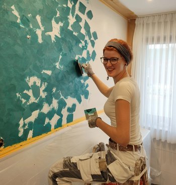 Stipendiatin getaltet eine Wand mit Tupftechnik
